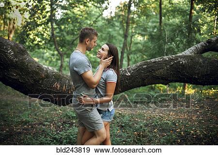 Caucasian couple hugging near tree branch View Large Photo Image Stock Photo - Caucasian couple hugging near tree branch. Fotosearch