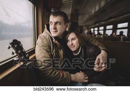 Stock Photograph - Caucasian couple hugging on train. Fotosearch