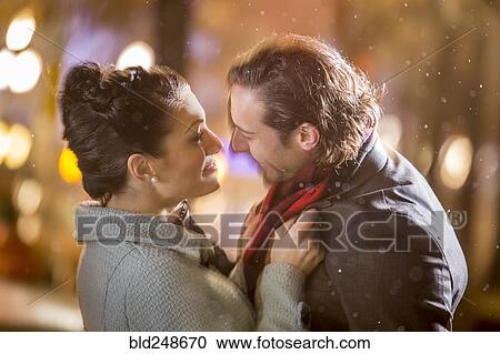 Caucasian couple hugging outdoors at night View Large Photo Image Stock Image - Caucasian couple hugging outdoors at night. Fotosearch