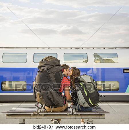 Caucasian couple kissing on bench near train View Large Photo Image Stock Photo - Caucasian couple kissing on bench near train. Fotosearch