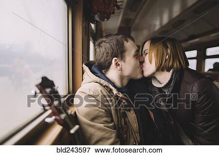 Stock Photo - Caucasian couple kissing on train. Fotosearch