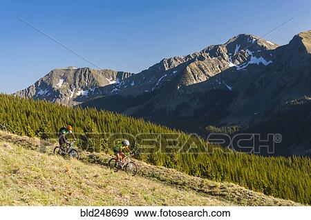 Stock Photo - Caucasian couple mountain biking. Fotosearch