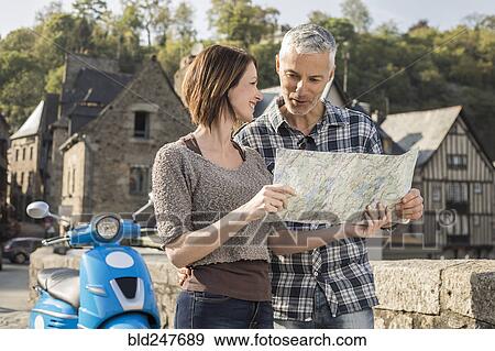 Caucasian couple near blue motor scooter reading map View Large Photo Image Stock Photo - Caucasian couple near blue motor scooter reading map. Fotosearch