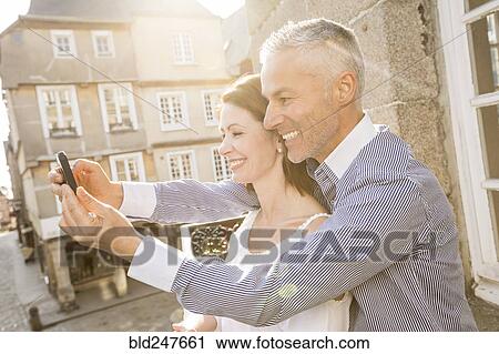 Caucasian couple posing for cell phone selfie View Large Photo Image Stock Image - Caucasian couple posing for cell phone selfie. Fotosearch