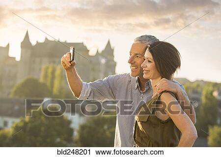 Stock Image - Caucasian couple posing for cell phone selfie. Fotosearch