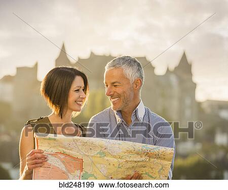 Stock Photo - Caucasian couple reading map. Fotosearch