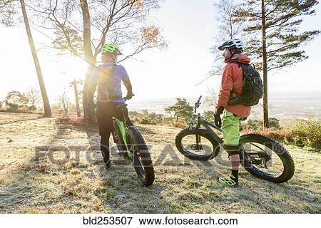 Stock Photo - Caucasian couple resting on bicycles. Fotosearch