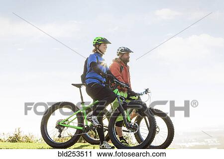 Caucasian couple riding bicycles View Large Photo Image Stock Image - Caucasian couple riding bicycles. Fotosearch