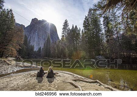 Caucasian couple sitting near river View Large Photo Image Stock Photograph - Caucasian couple sitting near river. Fotosearch