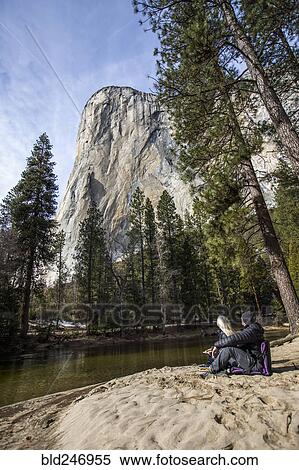 Stock Photography - Caucasian couple sitting near river. Fotosearch
