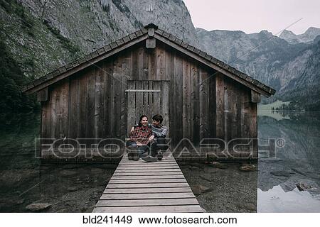 Caucasian couple sitting on dock at remote cabin View Large Photo Image Stock Photo - Caucasian couple sitting on dock at remote cabin. Fotosearch