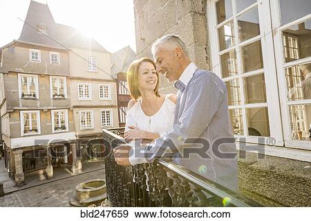 Caucasian couple smiling on balcony in city View Large Photo Image Stock Photo - Caucasian couple smiling on balcony in city. Fotosearch