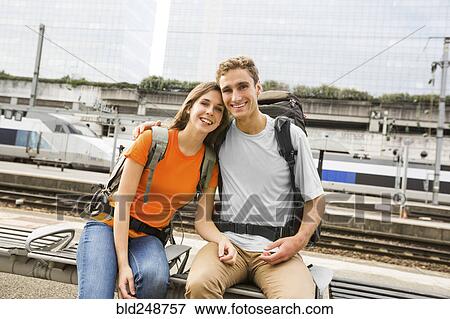 Caucasian couple waiting on bench at train station View Large Photo Image Stock Photo - Caucasian couple waiting on bench at train station. Fotosearch