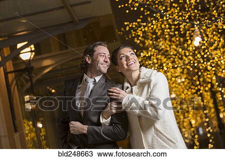Caucasian couple walking in city at night View Large Photo Image Stock Image - Caucasian couple walking in city at night. Fotosearch