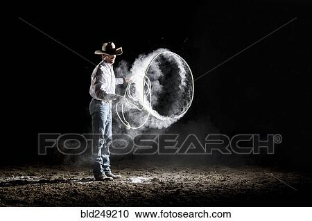 Stock Image - Caucasian cowboy spinning lasso. Fotosearch