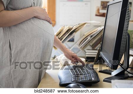 Stock Photo - Caucasian expectant mother using computer. Fotosearch