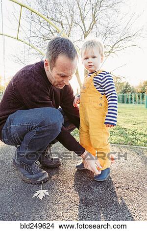 Picture - Caucasian father adjusting pants for son. Fotosearch
