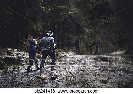 Stock Photograph - Caucasian father and daughter walking in woods. Fotosearch