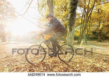 Picture - Caucasian father and son riding bicycle. Fotosearch