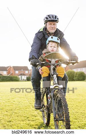 Stock Photograph - Caucasian father and son riding bicycle. Fotosearch