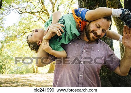 Caucasian father playing with son on shoulder View Large Photo Image Stock Image - Caucasian father playing with son on shoulder. Fotosearch
