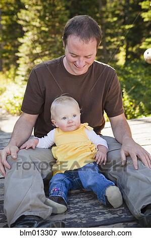 Stock Photo - Caucasian father sitting with daughter. Fotosearch