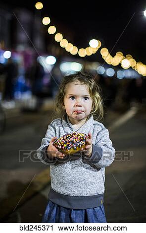 Caucasian girl eating donut outdoors at night View Large Photo Image Stock Image - Caucasian girl eating donut outdoors at night. Fotosearch