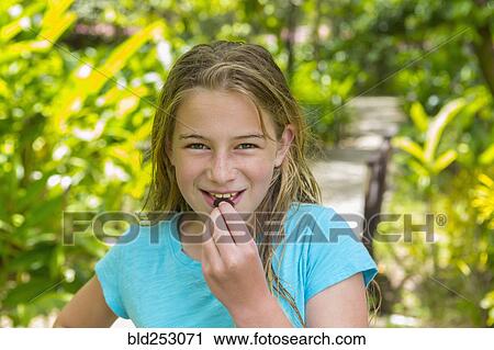 Stock Image - Caucasian girl eating snack. Fotosearch