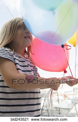 Caucasian girl holding multicolor balloons View Large Photo Image Stock Image - Caucasian girl holding multicolor balloons. Fotosearch