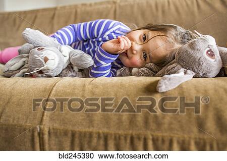 Caucasian girl laying on sofa sucking thumb View Large Photo Image Stock Image - Caucasian girl laying on sofa sucking thumb. Fotosearch