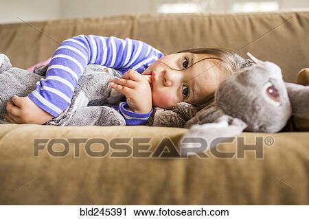 Caucasian girl laying on sofa sucking thumb View Large Photo Image Stock Image - Caucasian girl laying on sofa sucking thumb. Fotosearch