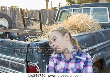 Stock Image - Caucasian girl leaning on truck . Fotosearch