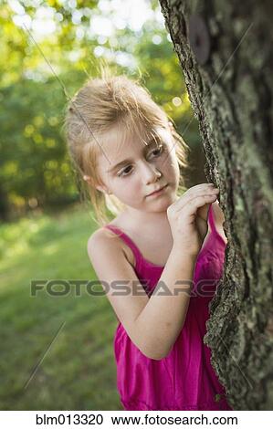 Stock Image - Caucasian girl looking at tree. Fotosearch