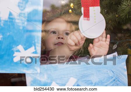 Caucasian girl pressing snowman decoration on window View Large Photo Image Stock Image - Caucasian girl pressing snowman decoration on window. Fotosearch