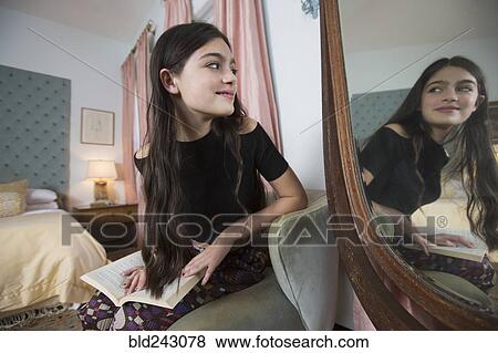 Caucasian girl reading book smiling in mirror View Large Photo Image Stock Photo - Caucasian girl reading book smiling in mirror. Fotosearch