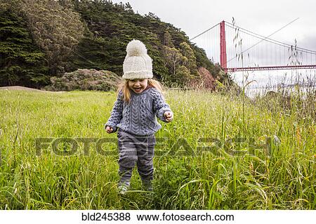 Caucasian girl running in grass near bridge View Large Photo Image Stock Photo - Caucasian girl running in grass near bridge. Fotosearch