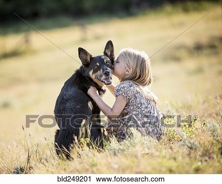 Caucasian girl sitting in field kissing dog View Large Photo Image Stock Image - Caucasian girl sitting in field kissing dog. Fotosearch