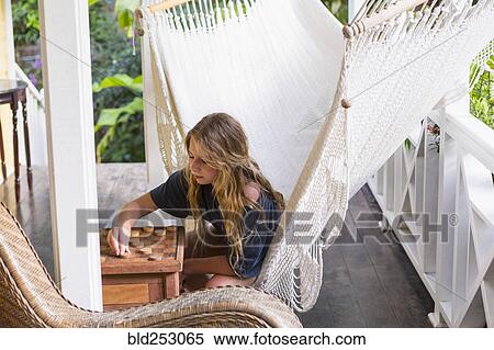 Caucasian girl sitting in hammock playing checkers View Large Photo Image Stock Photography - Caucasian girl sitting in hammock playing checkers. Fotosearch