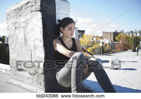 Caucasian girl sitting on rooftop View Large Photo Image Stock Photograph - Caucasian girl sitting on rooftop. Fotosearch