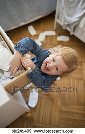 Stock Photo - Caucasian girl throwing diapers on floor. Fotosearch