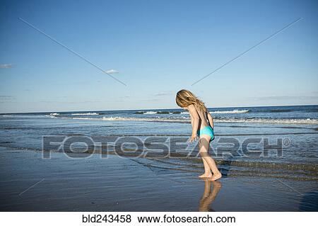 Stock Photo - Caucasian girl walking on beach. Fotosearch