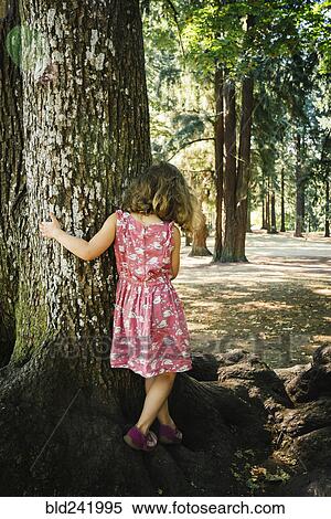 Stock Photography - Caucasian girl walking on tree roots. Fotosearch