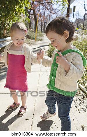 Caucasian girls holding hands on sidewalk View Large Photo Image Picture - Caucasian girls holding hands on sidewalk. Fotosearch