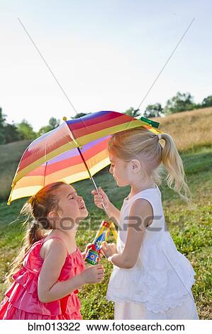 Caucasian girls in field with umbrella View Large Photo Image Stock Image - Caucasian girls in field with umbrella. Fotosearch