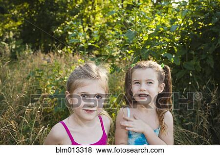 Stock Photo - Caucasian girls standing in woods. Fotosearch