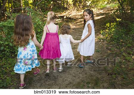 Stock Photo - Caucasian girls walking on forest path. Fotosearch