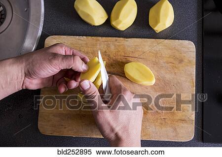 Caucasian hands cutting potatoes on cutting board View Large Photo Image Stock Photography - Caucasian hands cutting potatoes on cutting board. Fotosearch