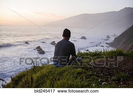 Caucasian man admiring ocean waves at sunset View Large Photo Image Stock Photo - Caucasian man admiring ocean waves at sunset. Fotosearch
