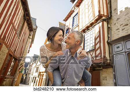 Caucasian man caring woman piggyback in city View Large Photo Image Stock Image - Caucasian man caring woman piggyback in city. Fotosearch