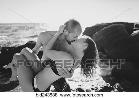Caucasian man carrying and kissing woman on beach View Large Photo Image Stock Photo - Caucasian man carrying and kissing woman on beach. Fotosearch